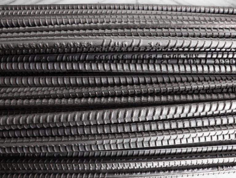 A pile of steel round rods storage and stacking in a warehouse for an industrial building